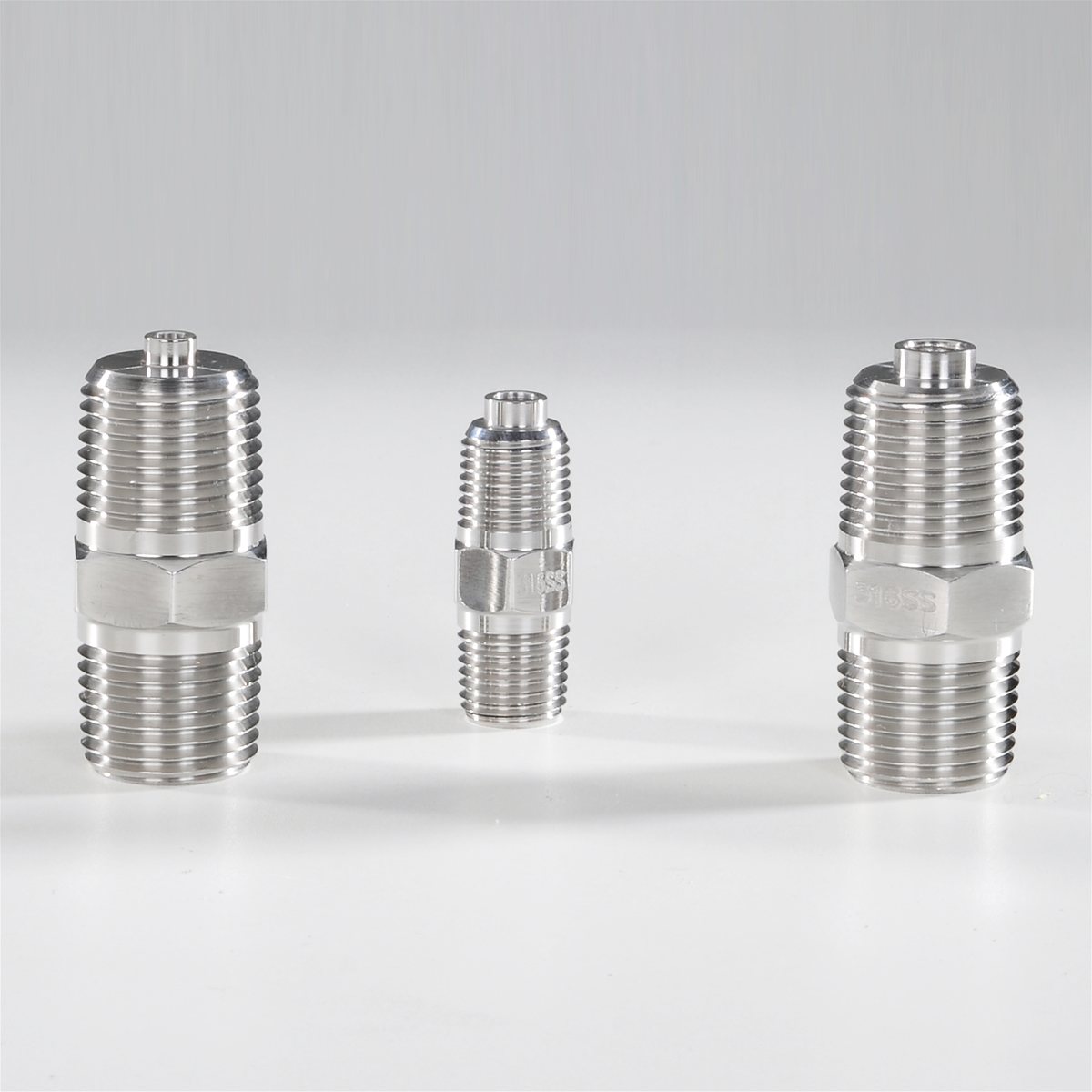 Three stainless steel hex weld fittings, threaded both ends